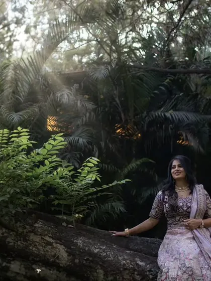 A serene portrait of the bride-to-be, seated on a large tree log in a forest. The beautiful light filtering through the trees highlights her joyful expression.