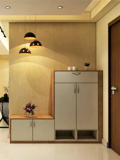 A simple and modern shoe cabinet with open slots at the bottom for easy access. The pendant lights provide focused lighting over the console area.