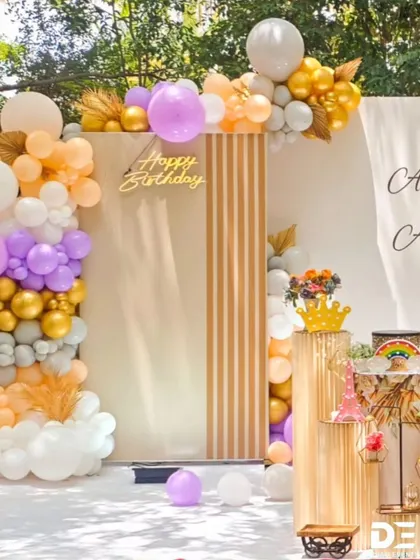 A bright and airy outdoor birthday setup with a modern backdrop and a beautiful pastel balloon garland, perfect for a daytime celebration.