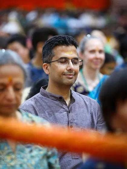 A participant meditates during a Homa ceremony. The sacred fire and chants help to purify the mind and environment, making it easier to slip into a state of deep, effortless meditation.
