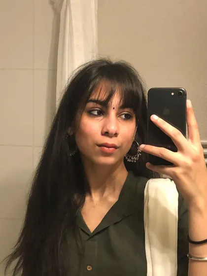A perfect mirror selfie showing how versatile front bangs can be. They work just as well for a traditional look as they do for a modern one, adding a touch of sophistication.