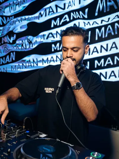 Hyping the crowd on the mic at SOHO Goa, with my name displayed on the screen behind me.