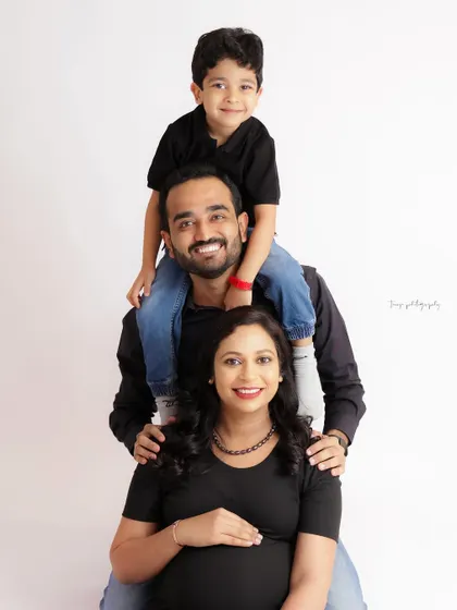 A fun "family stack" portrait. This playful pose is a great way to get genuine smiles and capture the happy energy of a growing family.