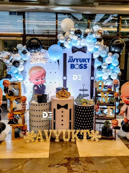 A sharp and stylish Boss Baby theme for Avyukt's first birthday. The decor includes a suspenders-and-bowtie backdrop, balloon columns, and cutouts of the boss himself.