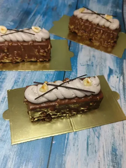 A close-up of the hazelnut mousse pastries, showing the crunchy nut coating and smooth cream topping.