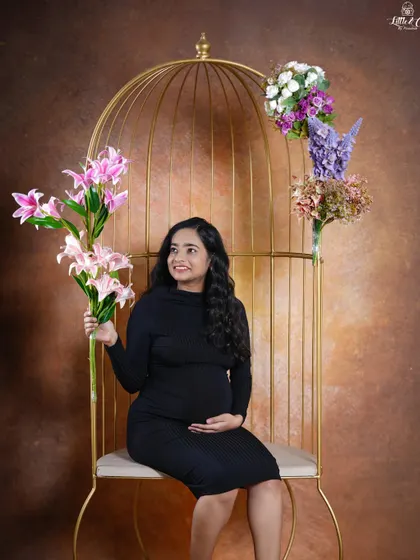 Another lovely solo portrait from the same setup. The mother-to-be holds a bouquet of lilies, adding a fresh and beautiful element to her maternity photo.
