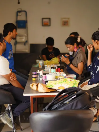 Another view of a workshop, where participants are chatting and creating together.