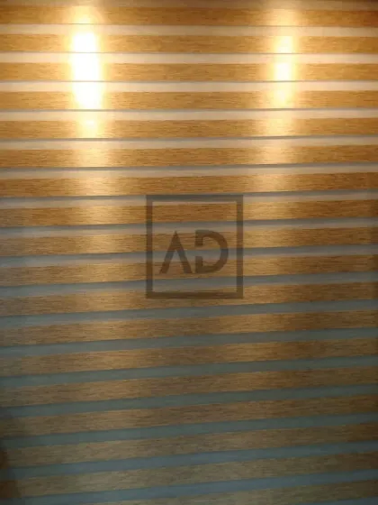 Here, the wooden zebra blinds are fully closed, providing privacy and a warm, textured wall effect. The backlighting highlights the clean, horizontal lines that are characteristic of this popular blind style.