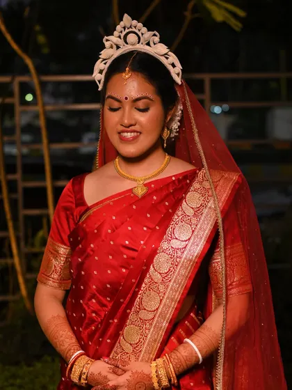 Piyashi in her full Bengali bridal attire. The red Banarasi saree, mukut, and minimal makeup come together for a look of pure grace.