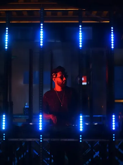 Framed by blue light bars, focused on the music.