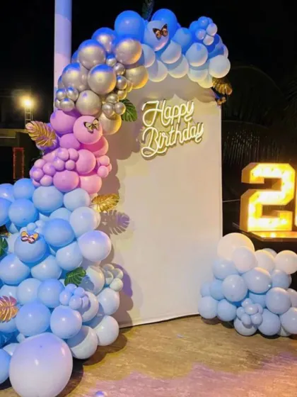 Another angle of the blue and pink birthday decor, showing the full balloon arrangement against a simple white backdrop.