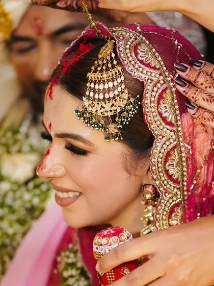 The sacred sindoor ceremony. You can see the bride's detailed mehandi as she participates in the wedding rituals, a constant and beautiful part of her special day.
