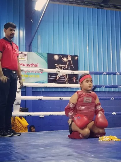 A moment of calm and respect before the fight begins. This young student is performing the Wai Kru Ram Muay, a traditional ritual in Muay Thai, at the national championship.