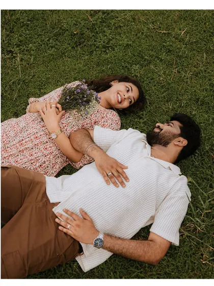 An aerial view of a couple lying in the grass, sharing a happy and intimate moment.