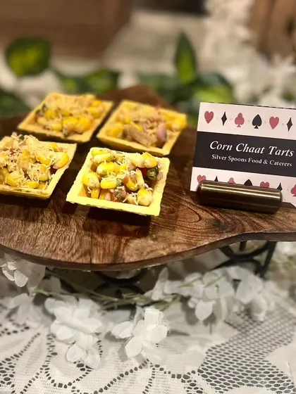 Our Corn Chaat Tarts are a delightful fusion appetizer. Crispy tart shells are filled with a zesty corn chaat mixture, perfect for a modern twist at a traditional cards party.