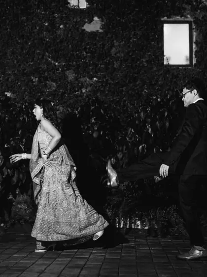A fun, candid black and white photo capturing a playful moment on the dance floor. It's all about documenting the real, uninhibited fun of the celebration.