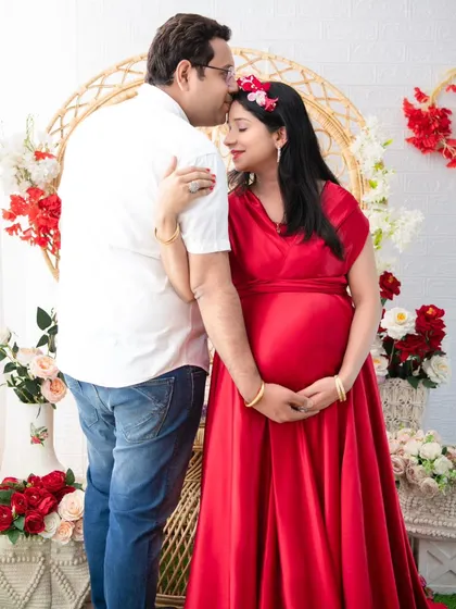 A tender moment captured as the husband kisses his wife's forehead. Her eyes are closed in contentment, creating a serene and romantic portrait.