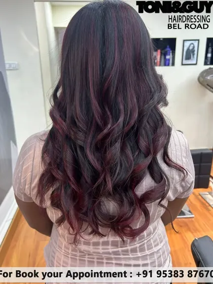We love this combination of dark hair with deep violet and red undertones. The colors are subtly woven through the hair and come to life in the light, especially with these soft waves.