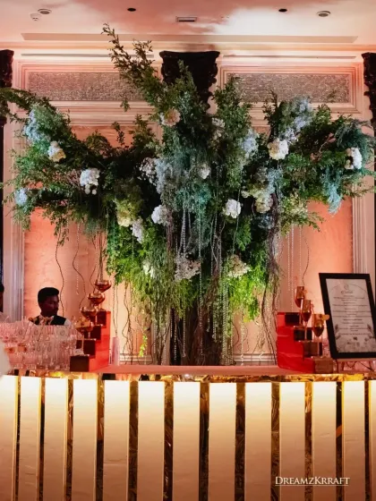 A stylish bar setup with a massive floral installation overhead. We ensure every functional area, including the bar, is a design statement that integrates seamlessly with the event's theme.