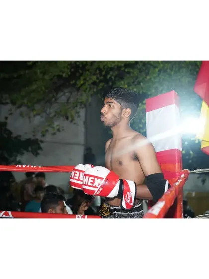 The calm before the storm. A fighter's intense focus in the corner before his Muay Thai bout begins.