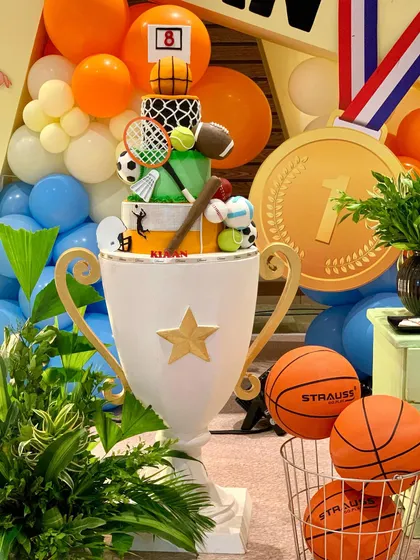 For the little champion, our trophy-shaped cake table is a winner. It's the perfect centerpiece for a sports-themed party, surrounded by basketballs and medals.