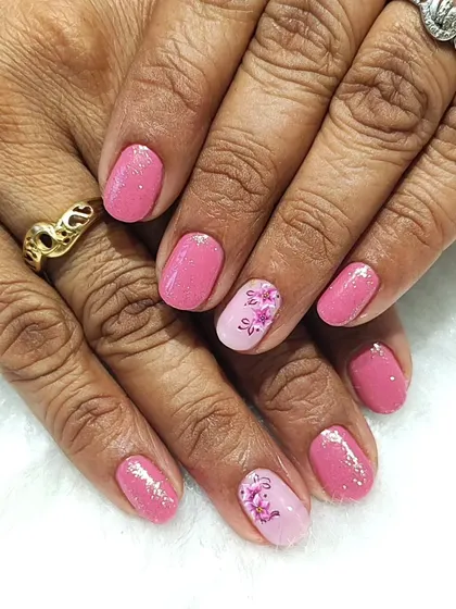 Pretty in pink with a floral touch. This design on short nails features a shimmery pink gel polish with a delicate, hand-painted floral accent nail.