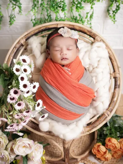 A wider view of our rustic basket setup. The combination of soft blankets, flowers, and hanging greenery provides a beautiful and textured backdrop for a sleeping newborn.