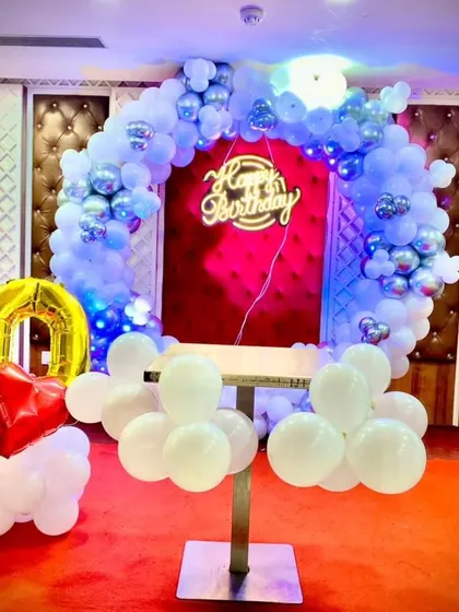 A slightly different angle of the 60th birthday stage setup, highlighting the large foil numbers and the glowing balloon arch.