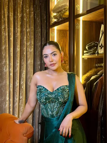 A confident pose showing off the full effect of the festive glam. The emerald green outfit is perfectly complemented by the warm, glowing makeup.