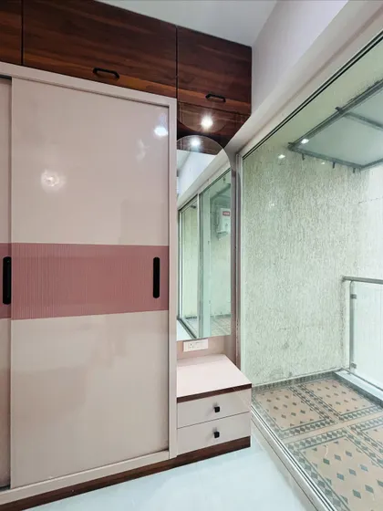 This sliding wardrobe includes a clever, narrow pull-out cabinet with a mirror and shelves, serving as a hidden dressing unit.
