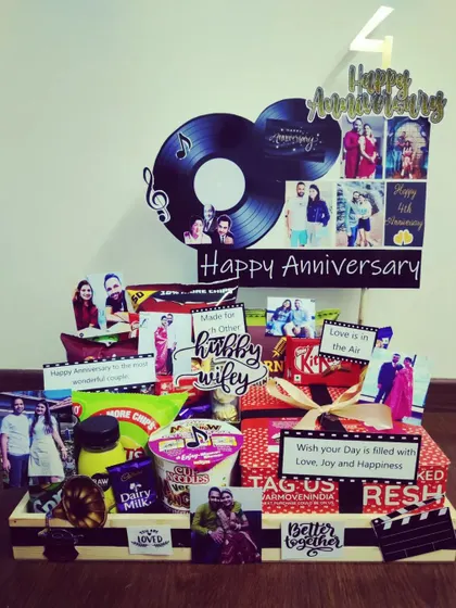 This anniversary hamper is themed around a love for music. It features a decorative vinyl record with a personal photo, musical notes, and a curated selection of snacks for the happy couple.