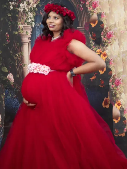 Feel like royalty in this red ball gown, a perfect rental for a grand and elegant maternity photoshoot.
