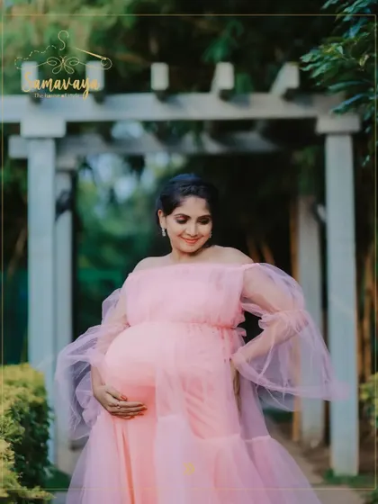A close-up of the mother-to-be in her pink gown, her expression full of love and peace. The soft focus on the garden background adds to the dreamy feel.