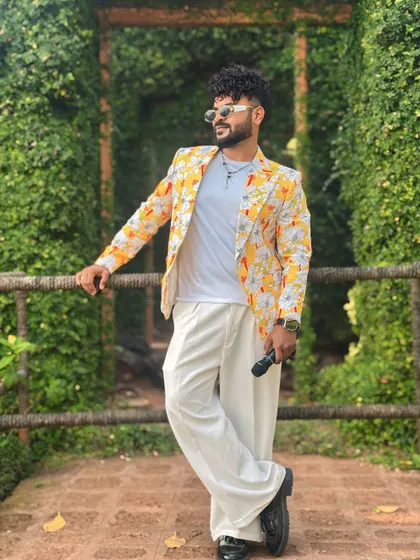 Leaning against a bridge in a lush green setting, my outfit still pops.