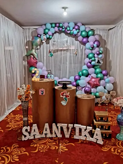 This is the same mermaid theme setup, showing the complete arrangement within the space. The drapes and carpeted floor complete the look for this indoor birthday celebration.
