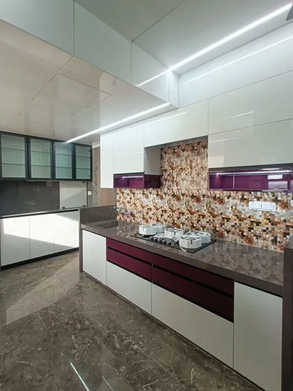 Another angle of the white and purple acrylic kitchen, highlighting the L-shaped layout. This design provides an efficient work triangle between the stove, sink, and prep areas.