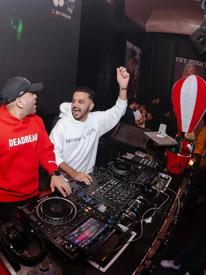 Sharing a high-energy moment with another DJ during a back-to-back set.