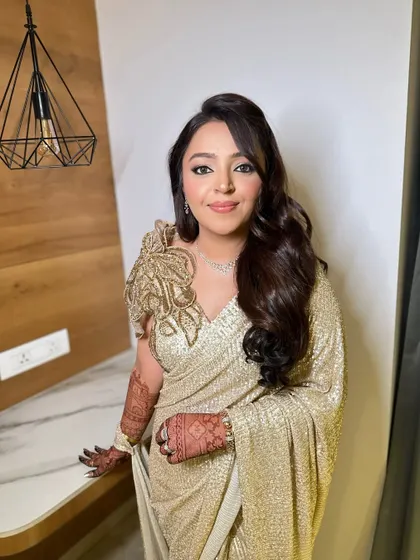 A full-length view of this stunning golden saree look. The makeup is designed to harmonize with the entire ensemble, creating a cohesive and elegant appearance.