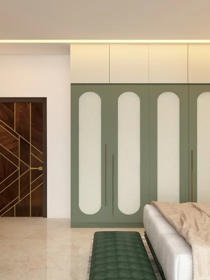 This bedroom showcases a beautiful wardrobe with sage green and white paneled doors. The design is complemented by a dark wood door with gold inlay, demonstrating our skill in mixing colors and materials.