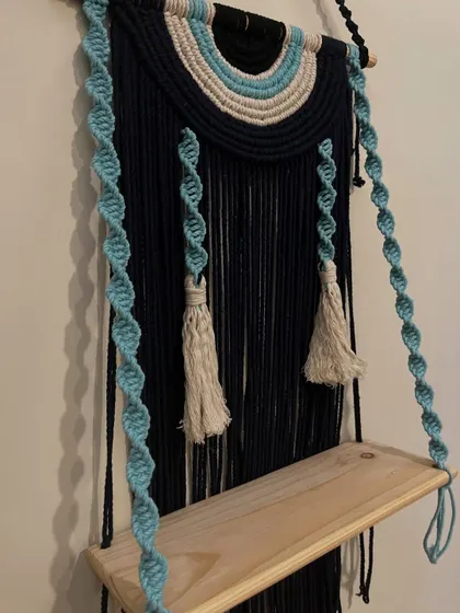 A close-up of the spiral knots and tassels on the evil eye wall shelf. It's these handcrafted details that make each piece special.