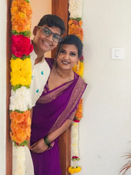 A happy moment with my son during our housewarming pooja. I designed both of our outfits for this special day. His is a custom-embroidered kurta and mine is a rich purple saree with a bespoke blouse.