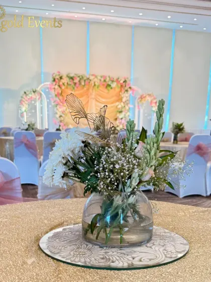 Every detail matters. This simple yet elegant table centerpiece, with white chrysanthemums and baby's breath, perfectly complements the larger pastel-themed stage in the background.