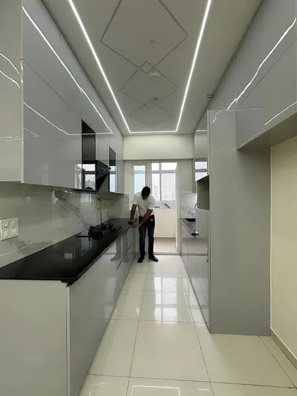 A final cleaning and check of a newly installed kitchen. This view shows the full length of the parallel layout, highlighting the ample counter space and storage we created.