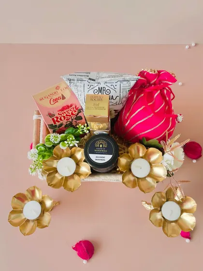 An overhead view of the macrame tray, showing the placement of four golden diyas around the hamper, ready to light up the festivities.