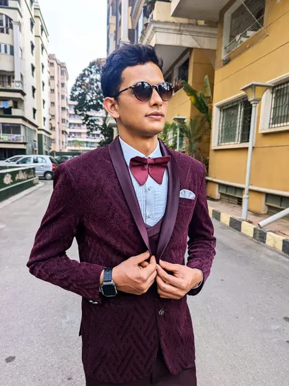 Make a statement in this wine maroon velvet textured tuxedo. The rich color and texture make it a unique and stylish choice for a formal event.