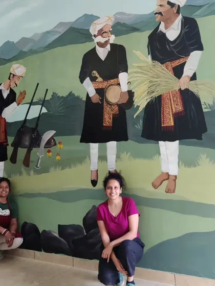 My partner and I with the completed Kailpodh festival section of the Coorg mural.
