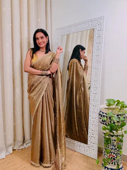 A glamorous golden tissue saree that is perfect for a wedding reception or a cocktail party. It's a statement piece that is sure to turn heads.