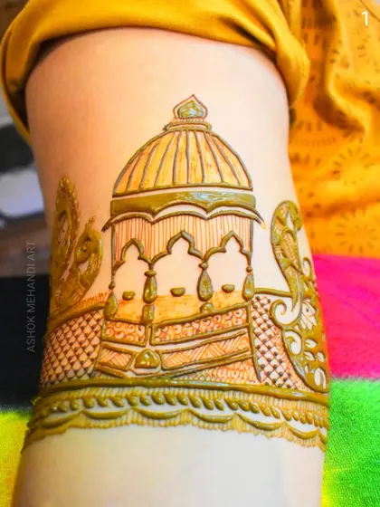 A close-up of an armband featuring a beautiful palace dome, flanked by peacocks. This kind of detail adds a regal touch to the upper arm portion of a bridal design.