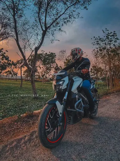 A beautiful shot of our Dominar 400 against the backdrop of a colorful sunset and lush green fields.