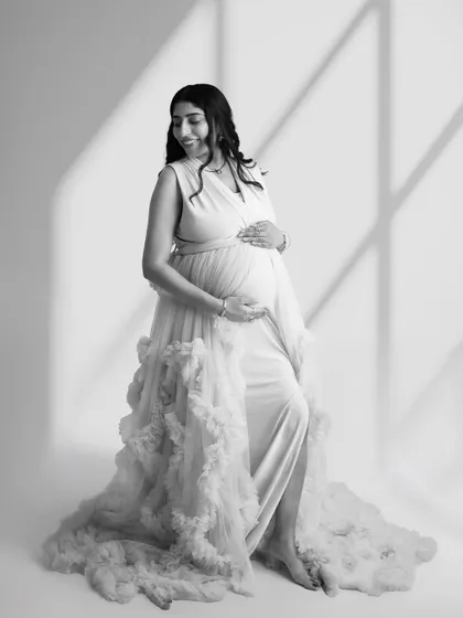 There is a timeless elegance to black and white photography. This classic portrait uses soft, natural light to create a serene and graceful image, focusing on the beautiful form of the mother-to-be.